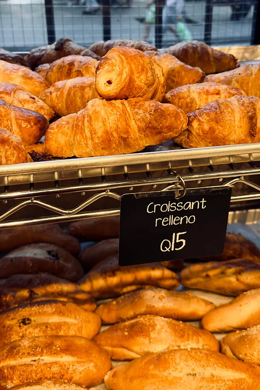 Croissants piled high in a bakery case